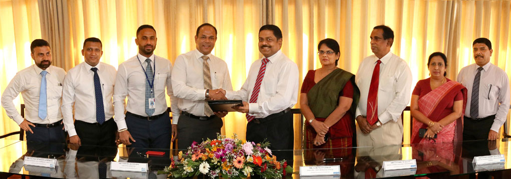 Commercial Bank’s Executive Director/Chief Operating Officer Mr S. Renganathan (fifth from right) and DIMO’s Executive Director Mr Vijitha Bandara exchange the agreement in the presence of senior management of the two companies.