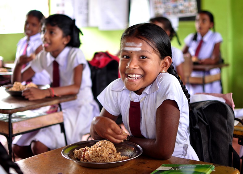 A primary grade student enjoys a nutritious meal