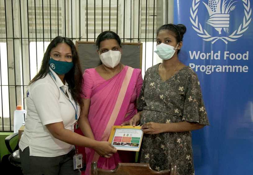 A pregnant mother receives a voucher from WFP (LBN Fill)