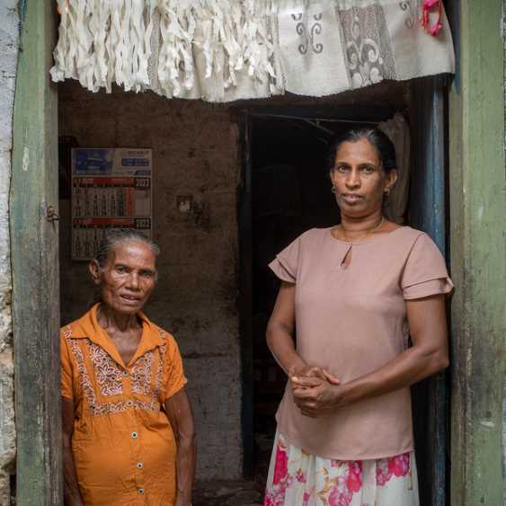 Sri Lanka.  P. Somawathi, 83, with  her neighbor Dhammika Damayanthi, 47, who brings her food each day
